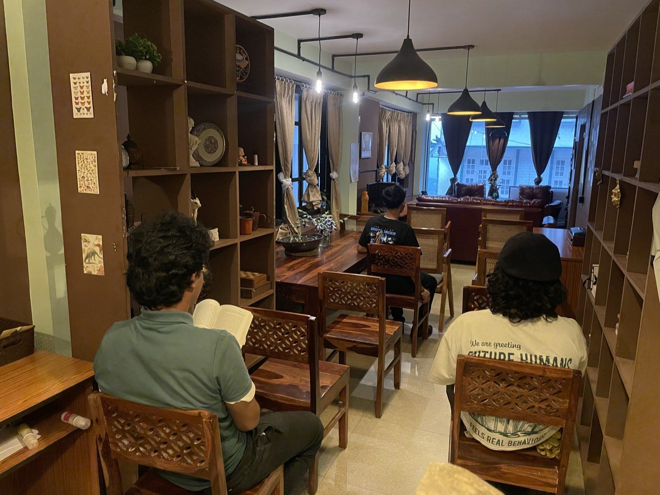 Members working at wooden desks between two walls of library shelving