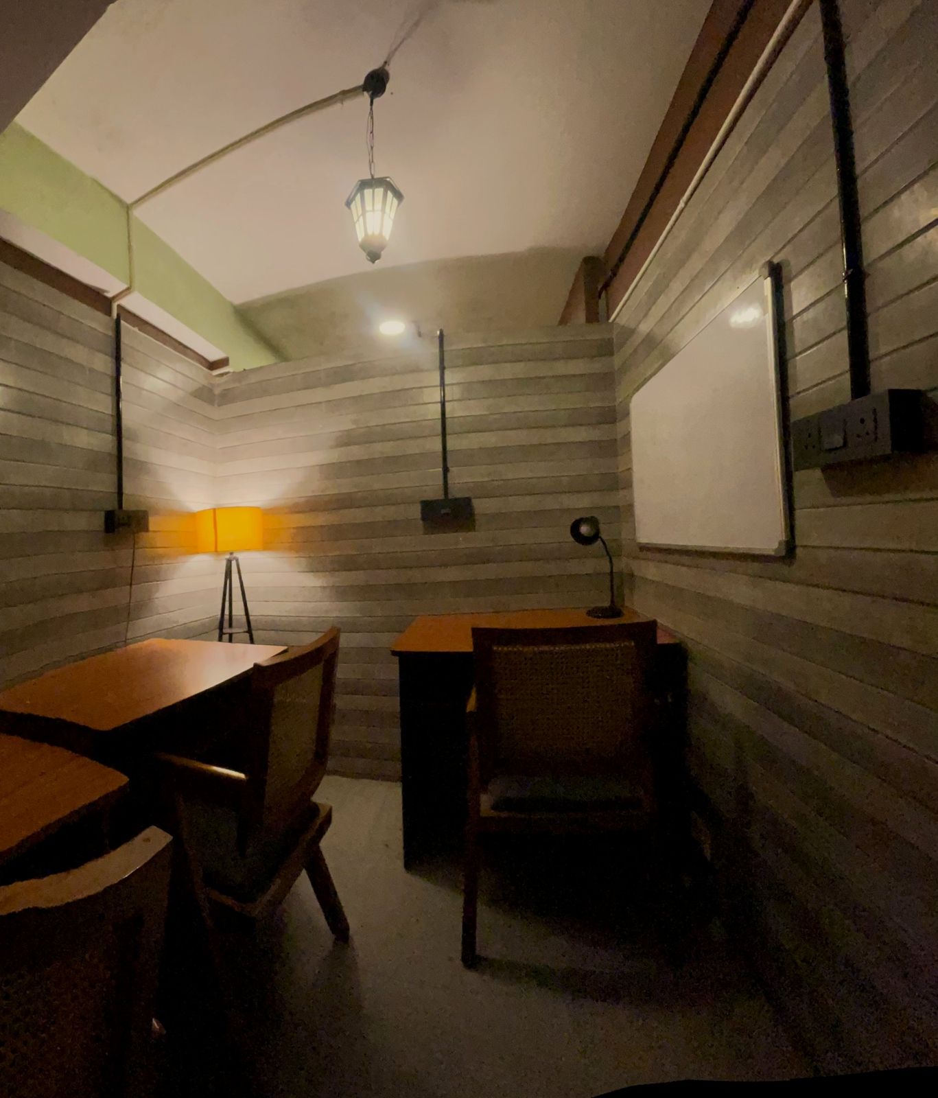 The pod lit by a floor lamp in the corner