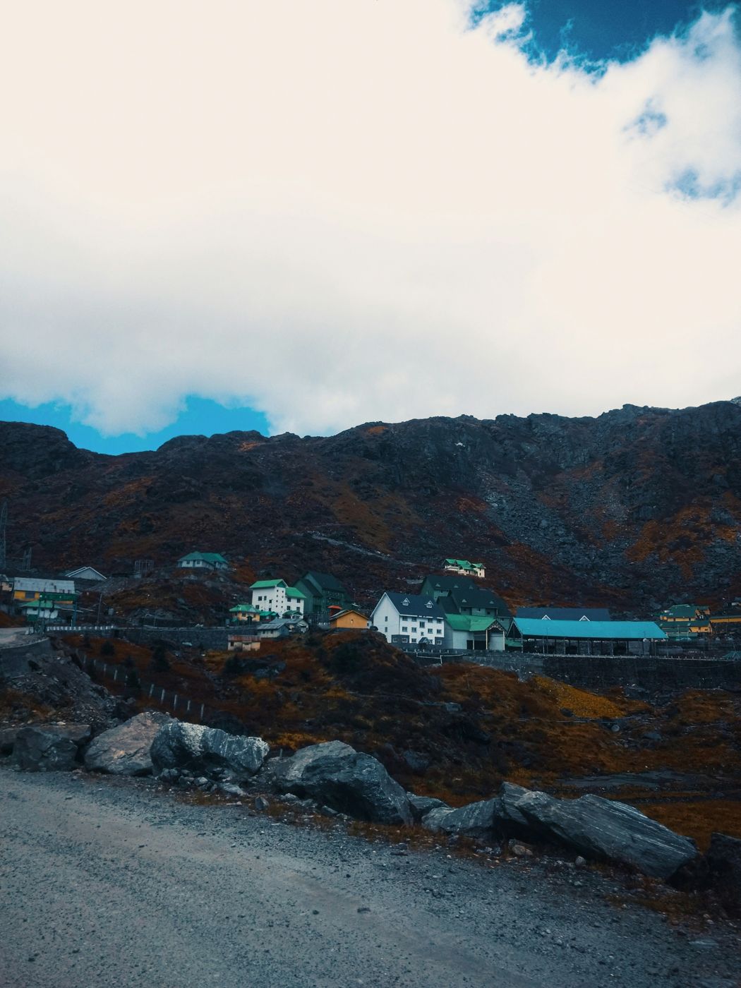 A village below snow peaks and heavy cloud in North Sikkim